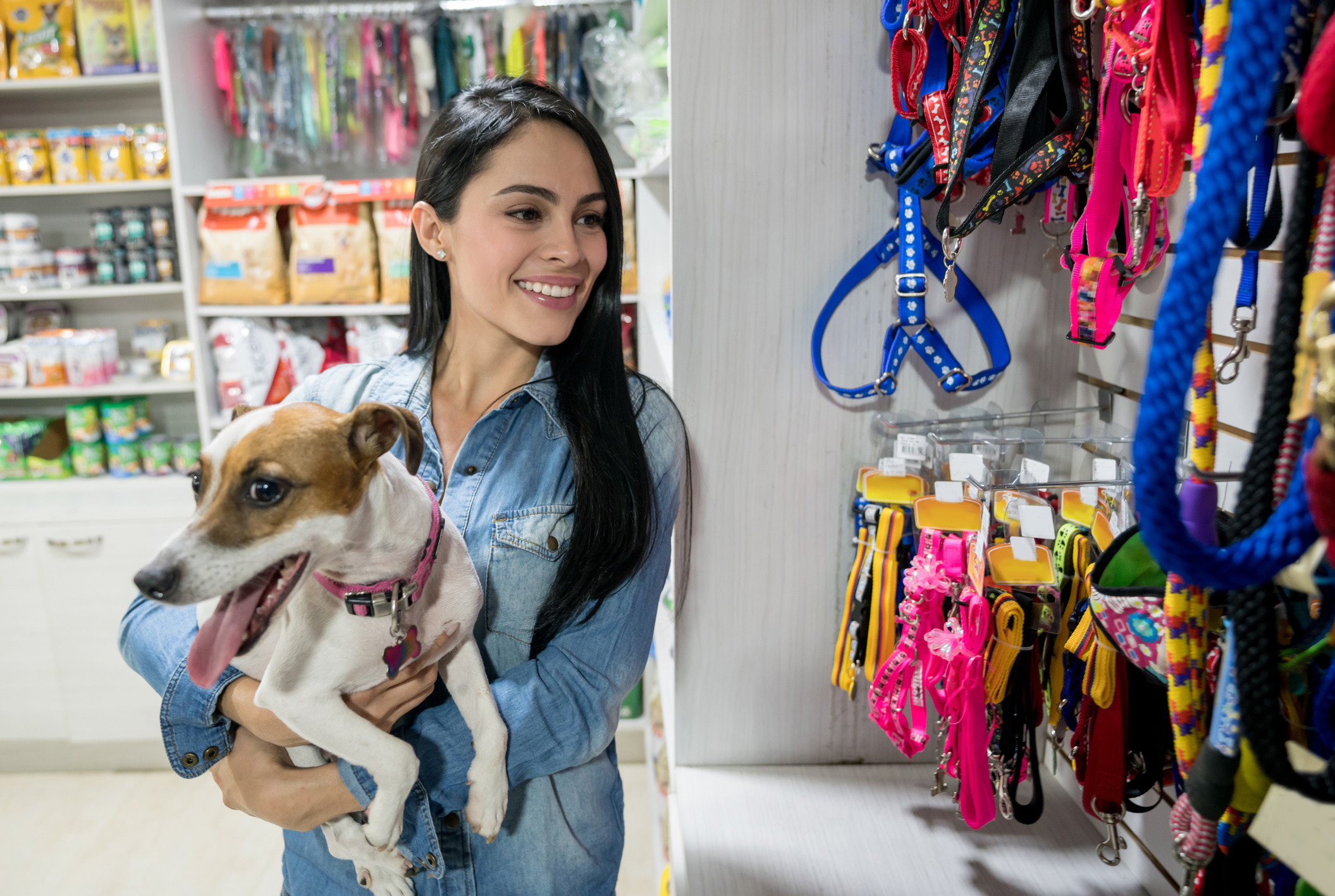 Happy woman at a pet shop holding a dog